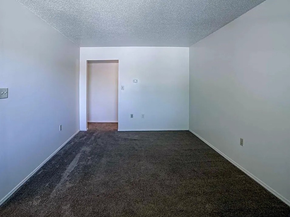an empty room with carpet and white walls