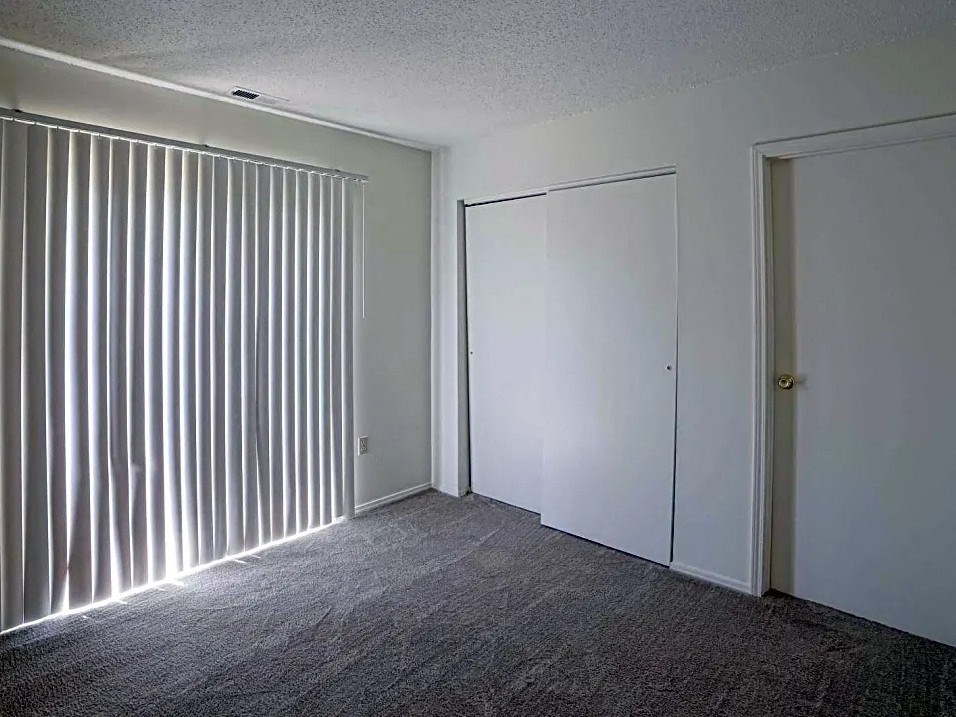 an empty room with a large window and a door