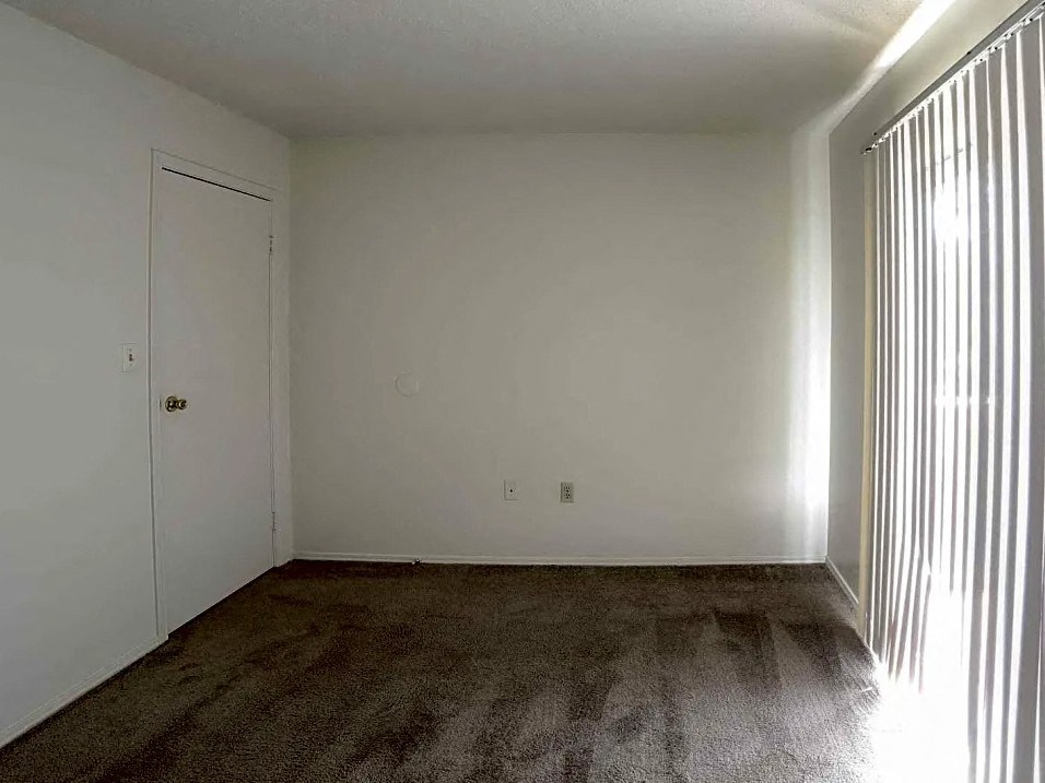 an empty living room with white walls and a door