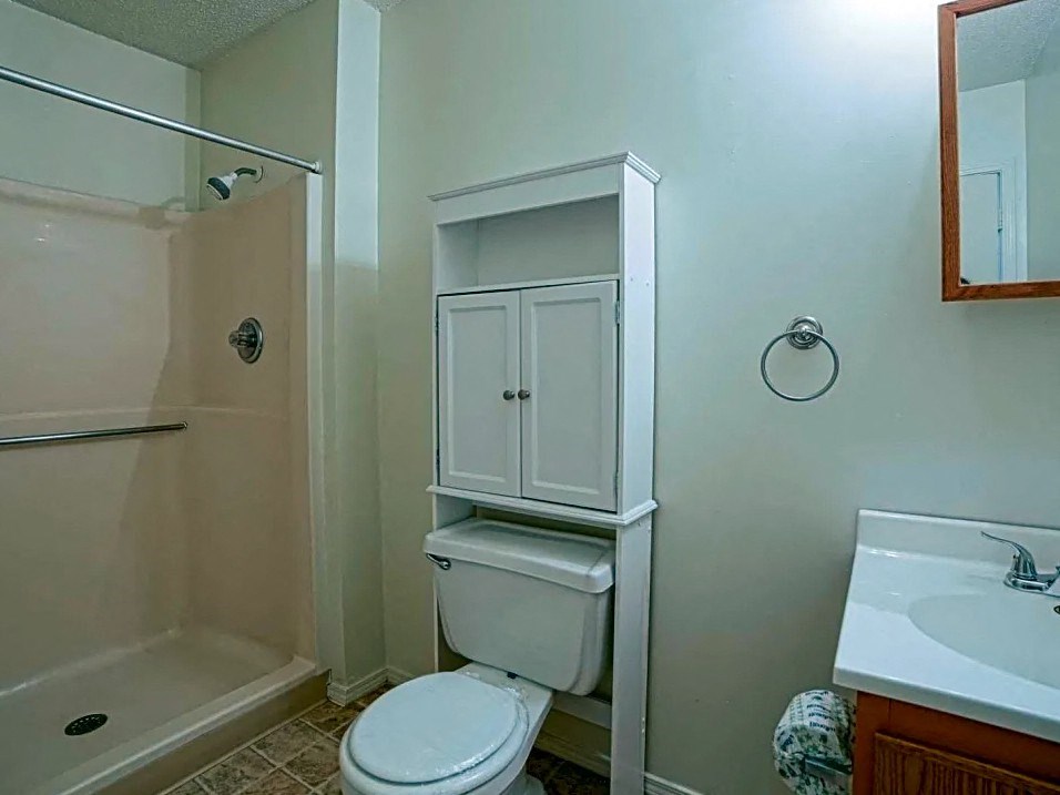 a bathroom with a toilet and a sink and a shower