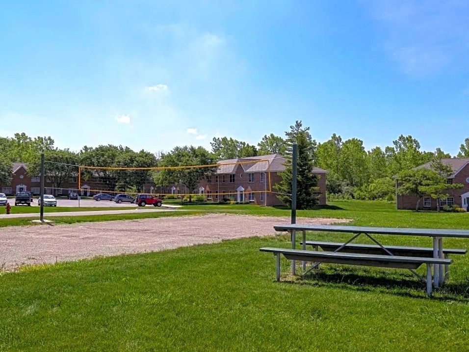 a picnic table in the grass in front of a house