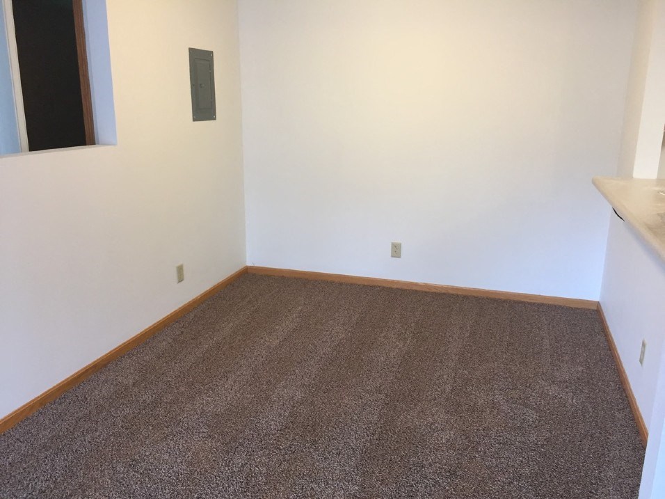 a room with a carpeted floor and a white wall