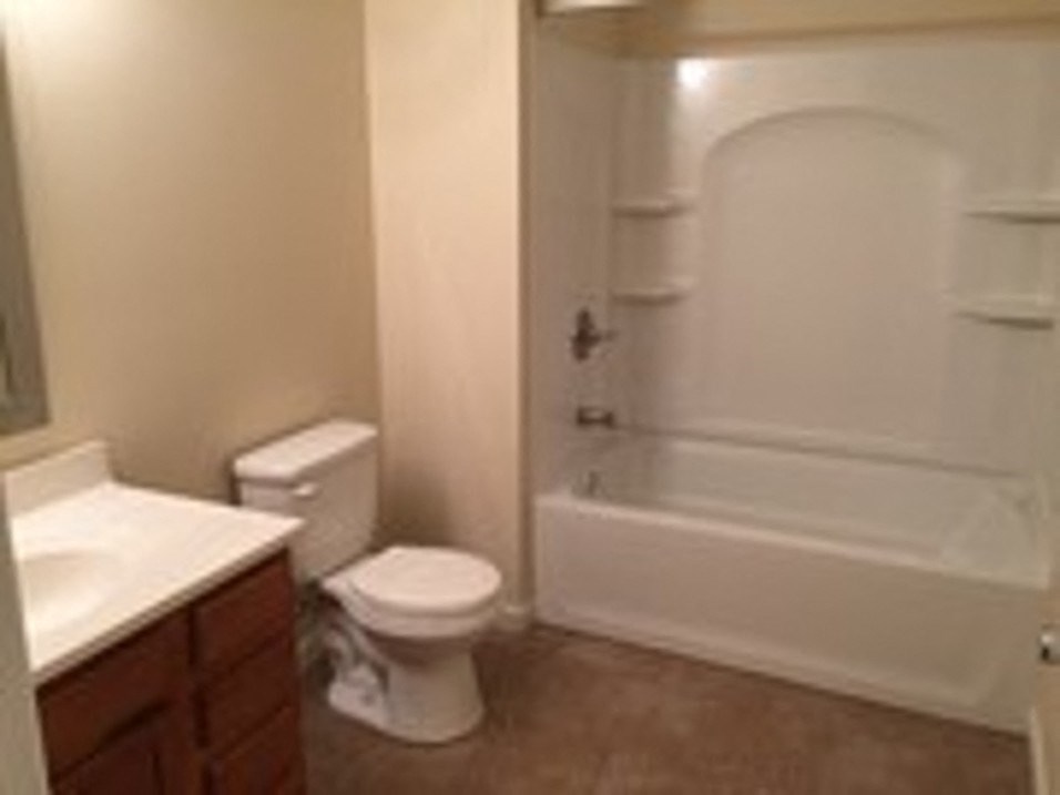 a bathroom with a toilet and a tub and a sink