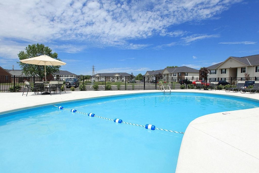 a large swimming pool with apartment buildings in the background