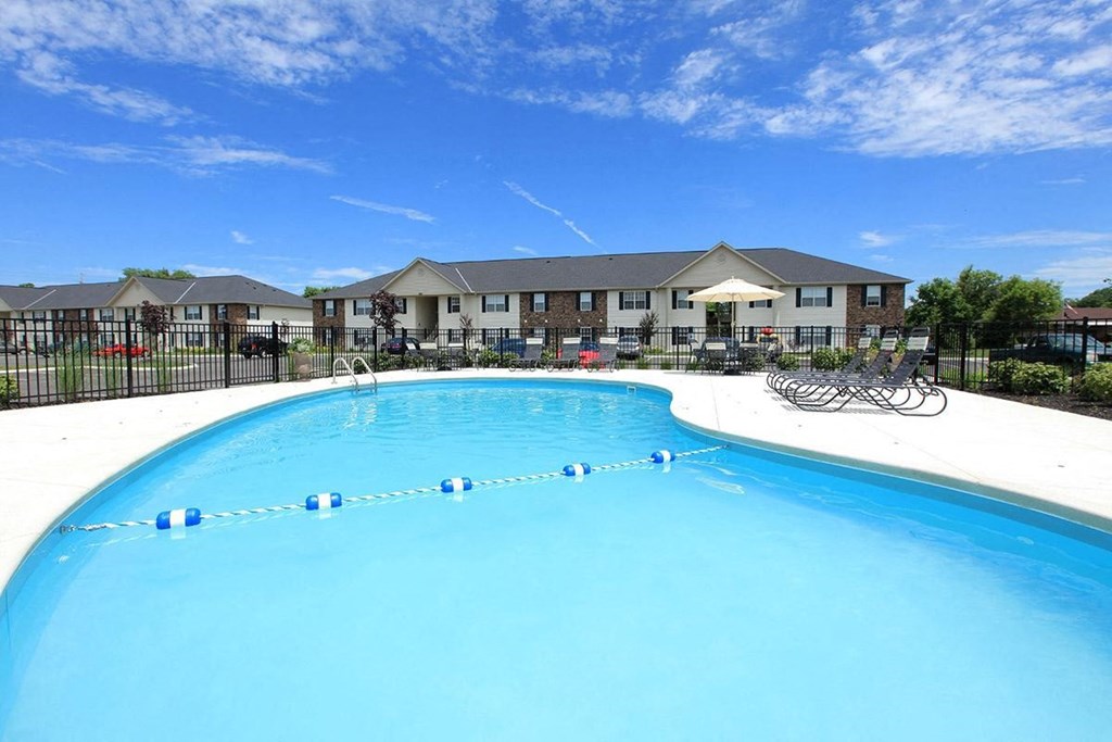 a large swimming pool with a building in the background