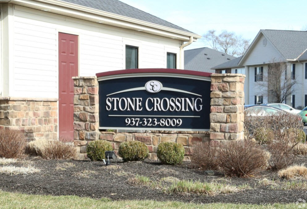 a stone crossing sign in front of a house