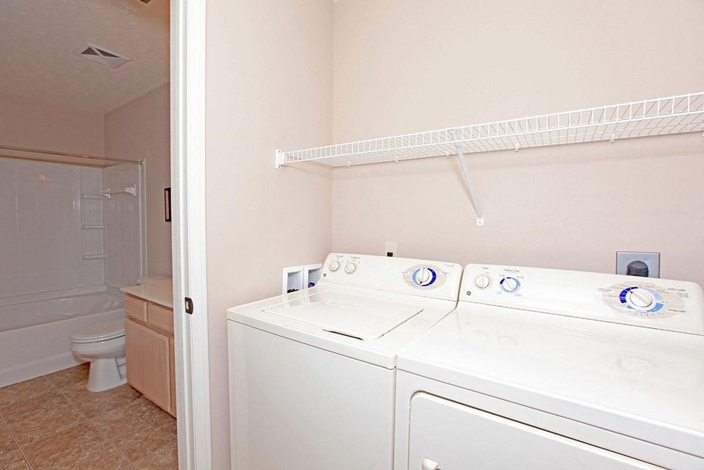 a white washer and dryer in a room with a bathroom