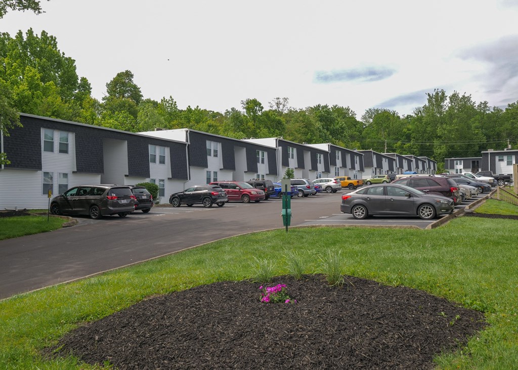 a row of houses with cars parked in a parking lot