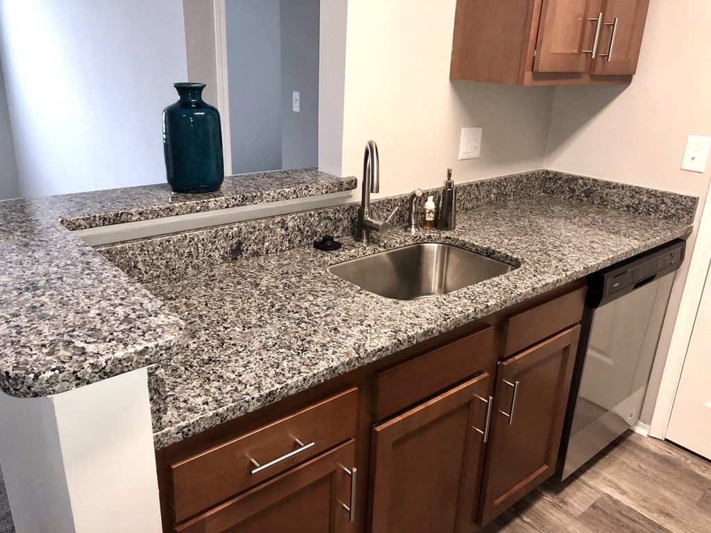 a kitchen with granite counter tops and wooden cabinets