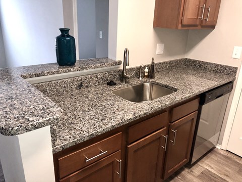 a kitchen with granite counter tops and wooden cabinets