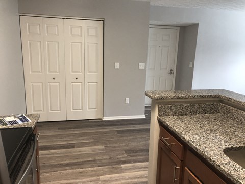 a kitchen with granite counter tops and a door to the living room