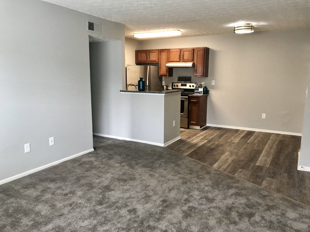 an empty living room with a kitchen in it