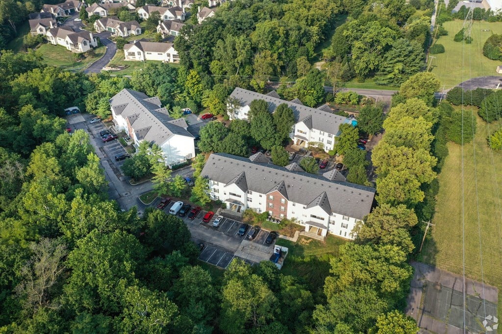 A bird's eye view of a residential area with houses and parked cars.