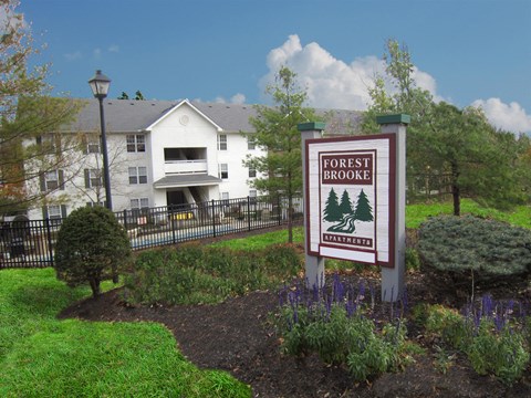 A sign that says Forest Brook in front of a building.