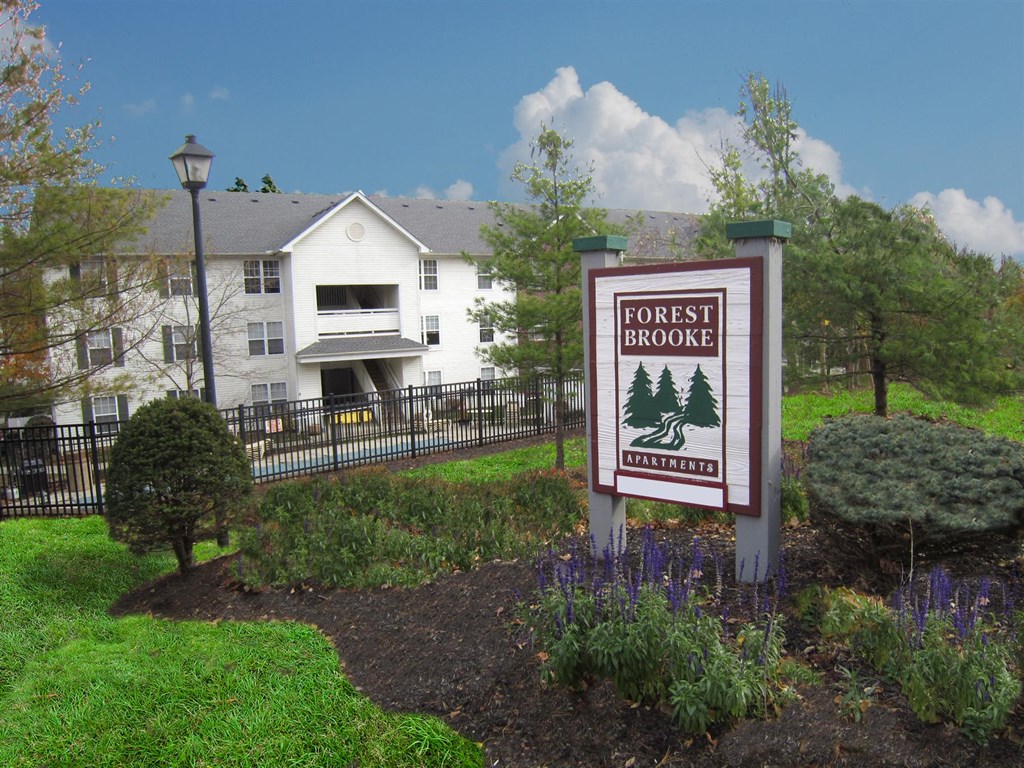 A sign that says Forest Brook in front of a building.