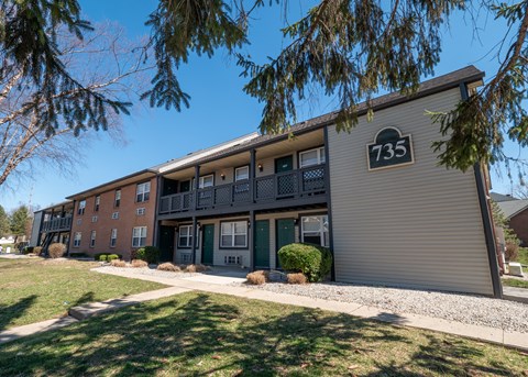 Apartment building number 735 with a tree branch in the foreground.