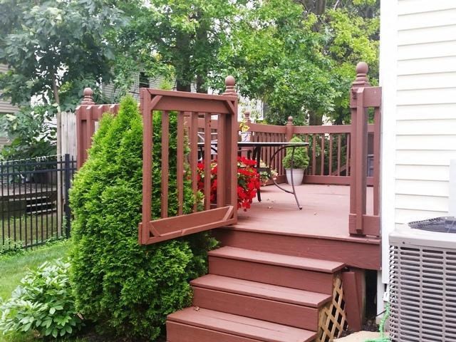 a deck with a wooden railing and stairs