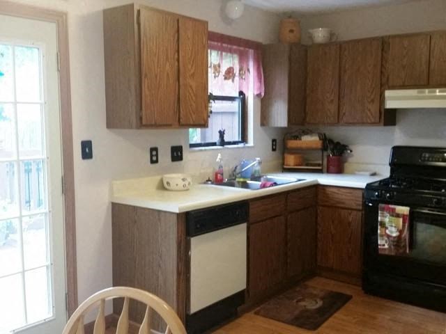a kitchen with a stove a sink and a window
