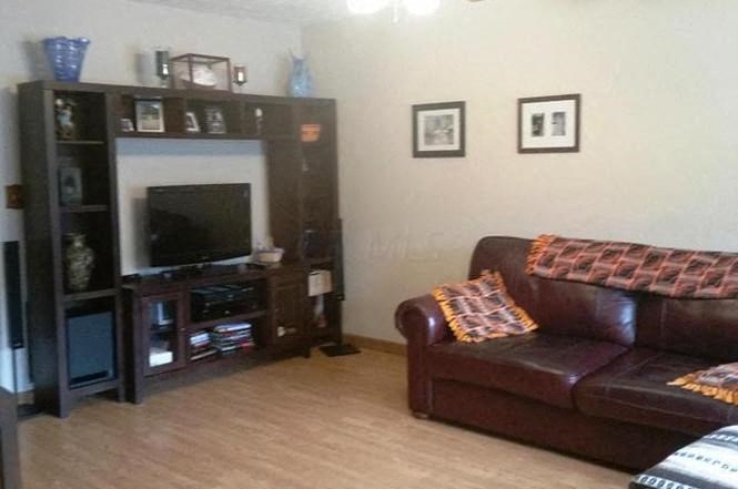 a living room with a leather couch and a television
