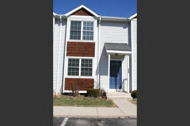 a white house with a blue door and a sidewalk