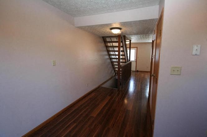 a hallway with a wood floor and a staircase