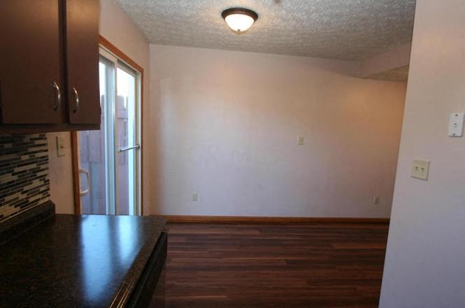 an empty room with wood floors and a white wall