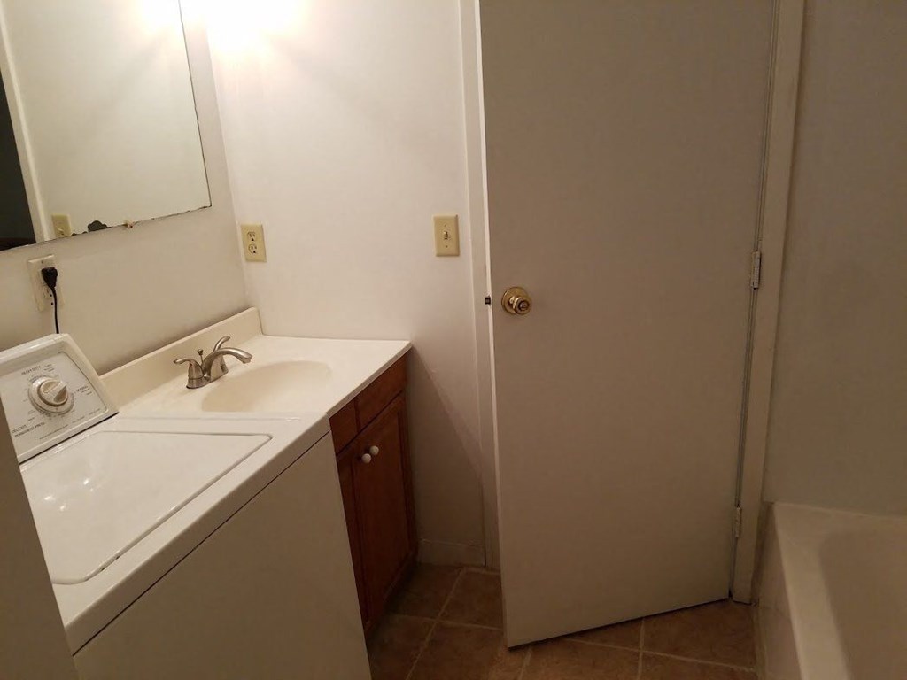 a bathroom with a sink and a mirror and a door