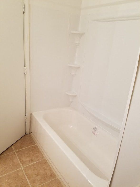 a white bathroom with a shower and a bath tub