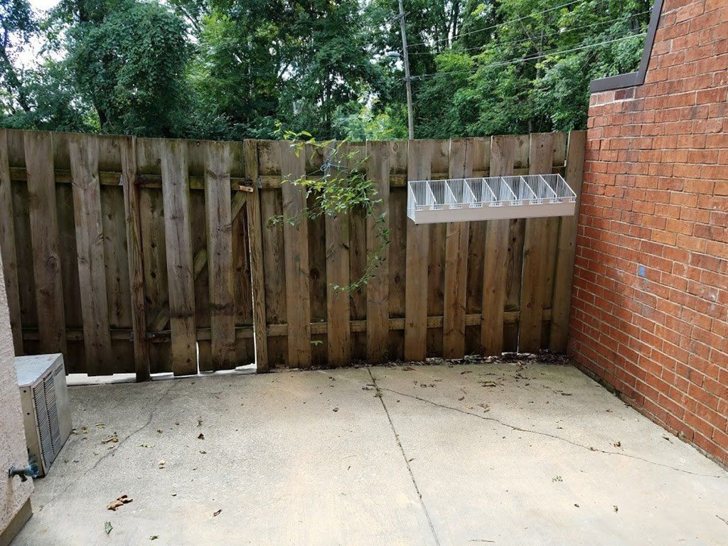 a backyard with a wooden fence and a brick wall