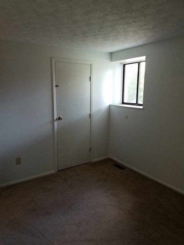 a white room with a window and a door