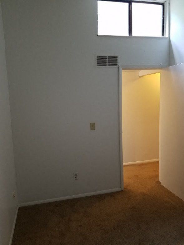 an empty room with an open door and a window