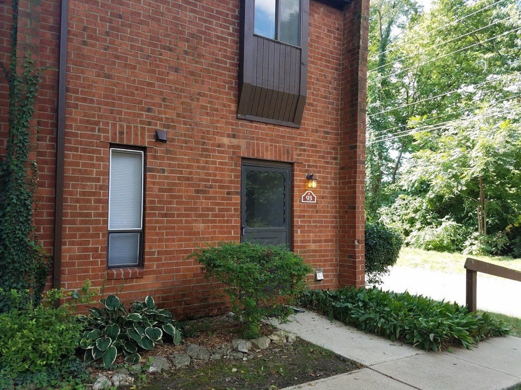 a brick building with a black door and a sidewalk