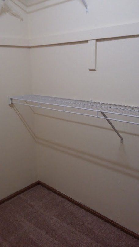 an empty closet with a shelf on the wall
