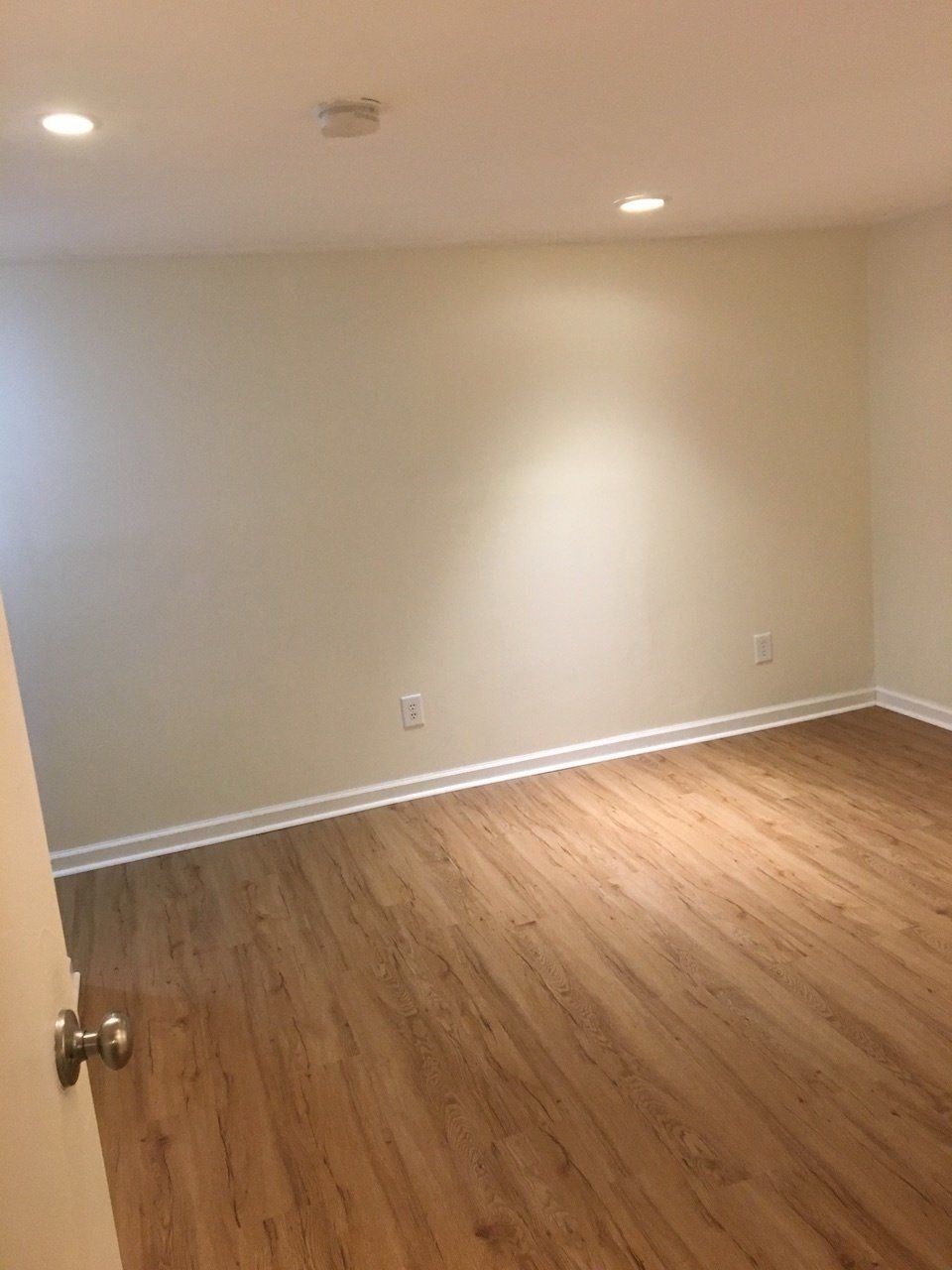 an empty room with wooden floors and white walls