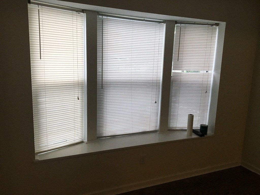 a window with three blinds in a room