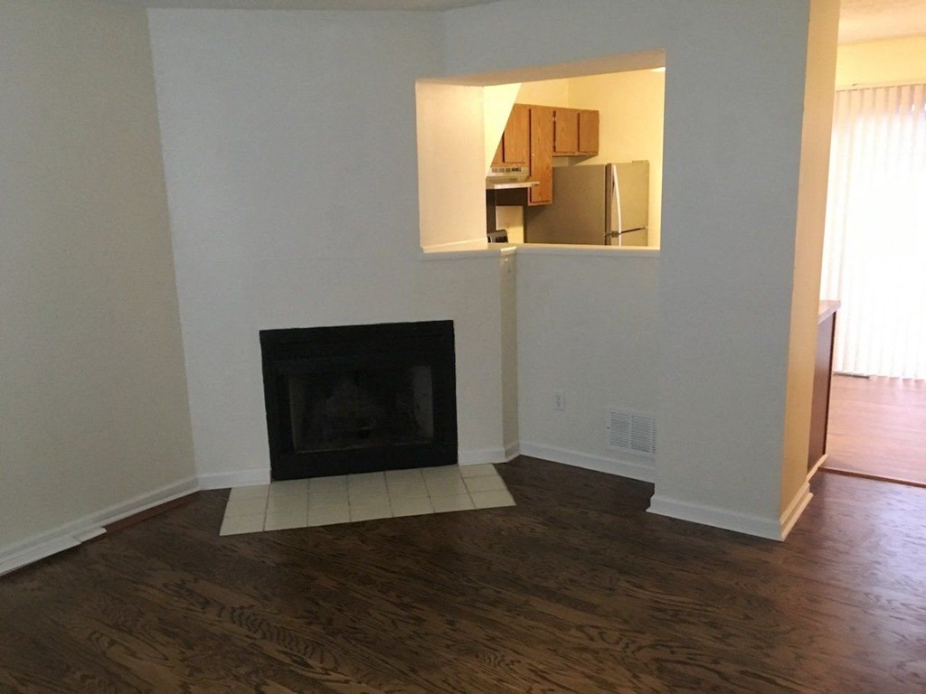 a living room with a fireplace and wooden floors