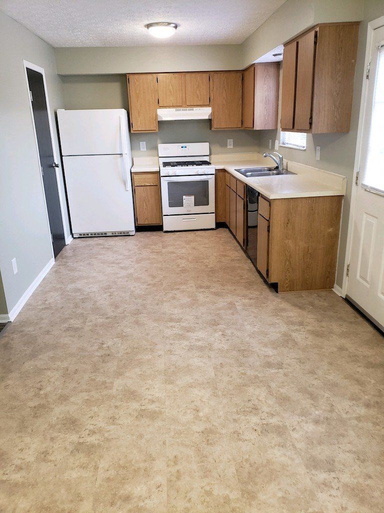 a kitchen with a stove refrigerator and a sink