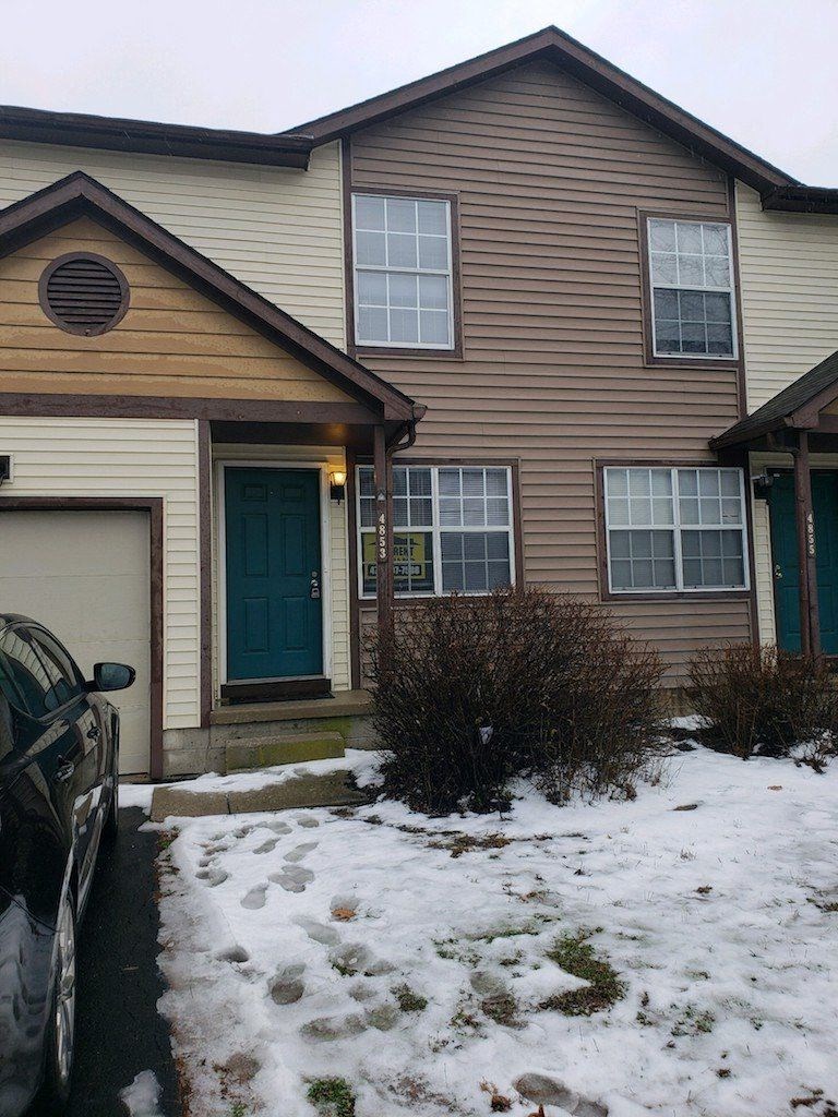 a house with a car parked in the snow
