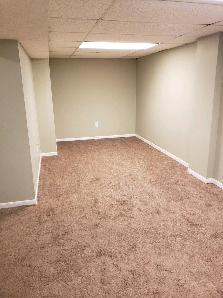 an empty room with carpet and a wall