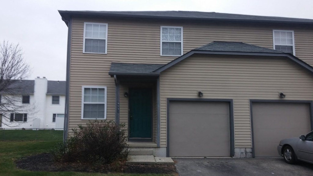 the front of a house with two garage doors