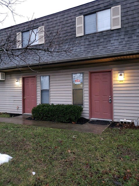 the front of a house with two red doors