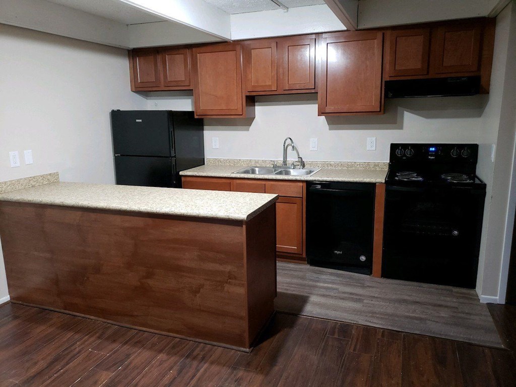 a kitchen with wooden cabinets and black appliances