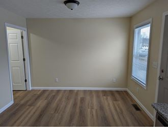an empty living room with wood floors and a white door