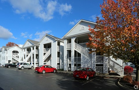A white building with a red car in front.
