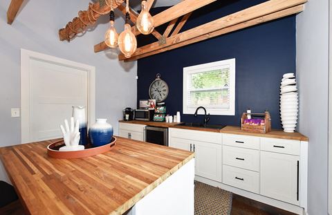 a kitchen with blue walls and white cabinets and a wooden counter top