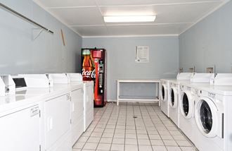 a row of washing machines in a laundry room with a vending machine