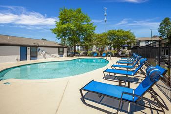 a swimming pool with lounge chairs at The Benton Apartment Homes, Hoover, Alabama