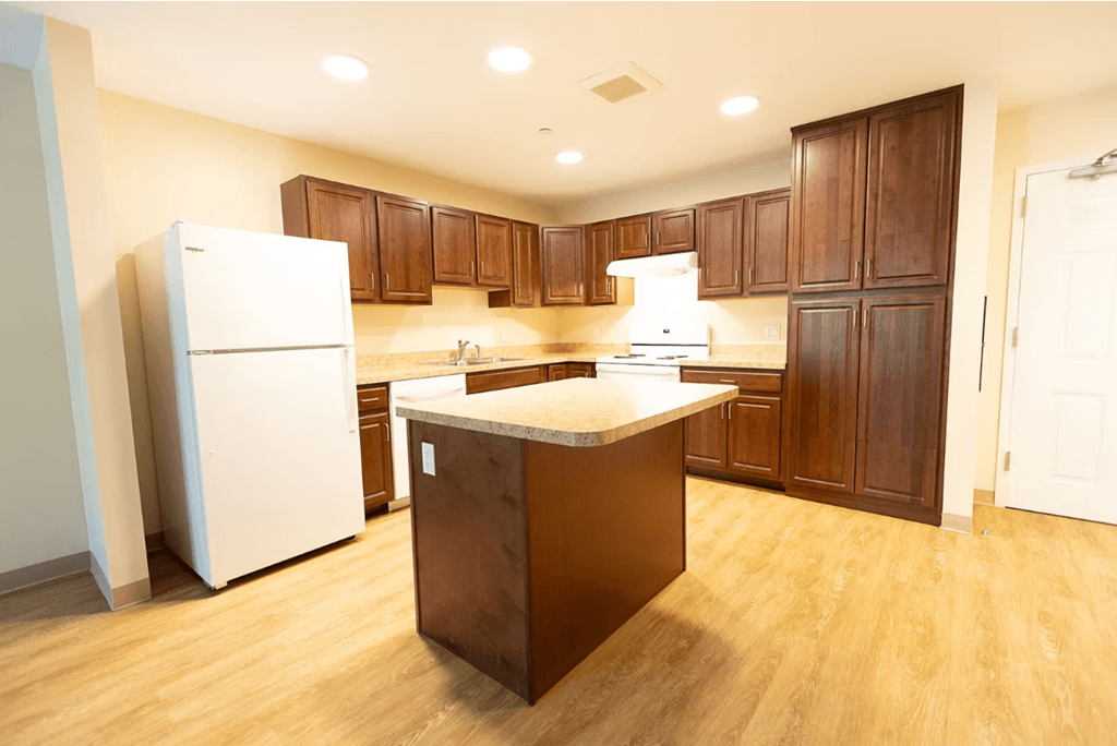 A kitchen with wooden cabinets and a white refrigerator.
