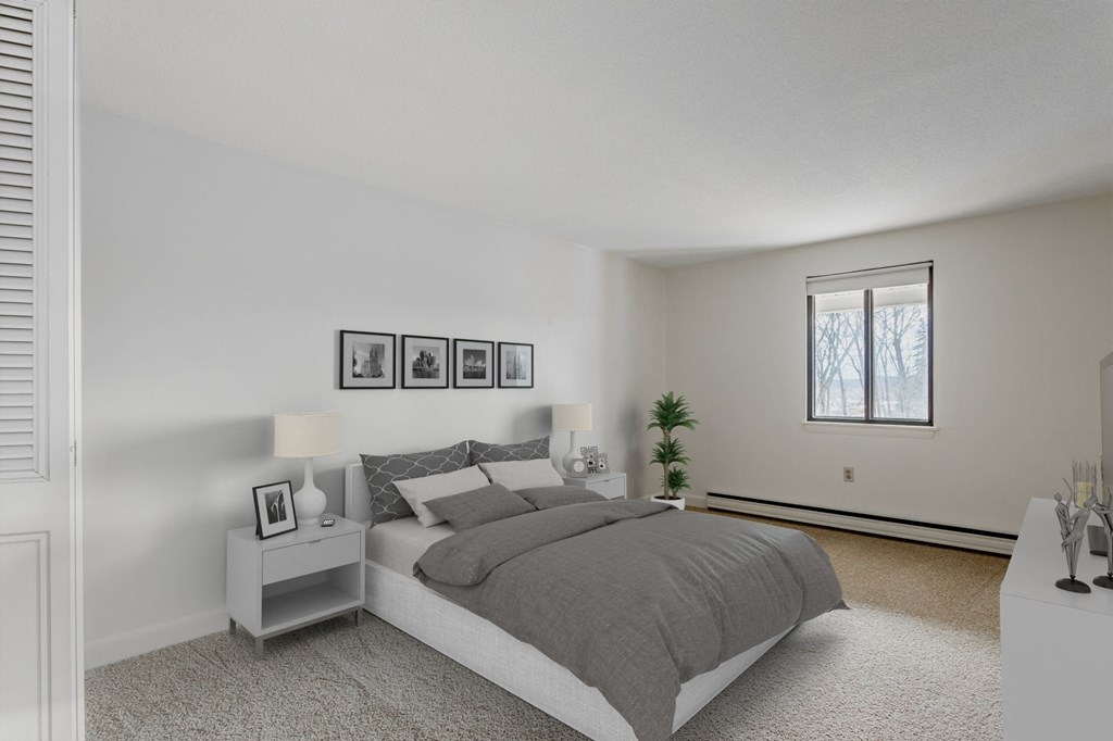 A bedroom with a bed, nightstands, and pictures on the wall.