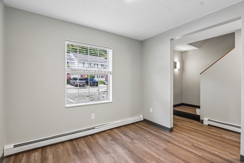 A room with a wood floor and a picture of a building on the wall.